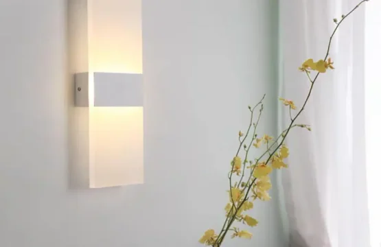 Aplică LED dreptunghiulară albă cu difuzor acrilic aprinsă pe un perete minimalist