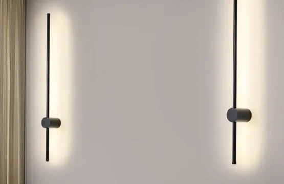 Aplică LED liniară neagră de 60cm tip baghetă aprinsă pe un perete alb